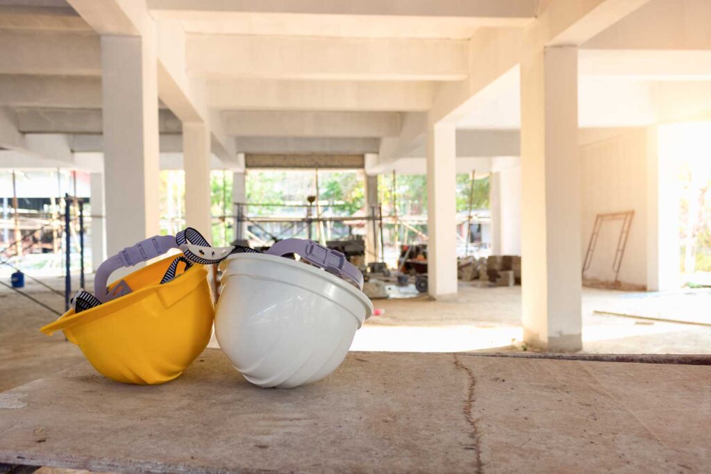 Dos cascos de obra en una obra de un edificio. Limpiezas Regueiro es una empresa de limpieza de casas, viviendas. pisos, comunidades, oficinas y empresas ubicada en la provincia de Ourense.