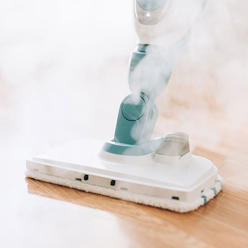 Una aspiradora de vapor limpiando un suelo de tarima. Limpiezas Regueiro es una empresa de limpieza de casas, viviendas. pisos, comunidades, oficinas y empresas ubicada en la provincia de Ourense.